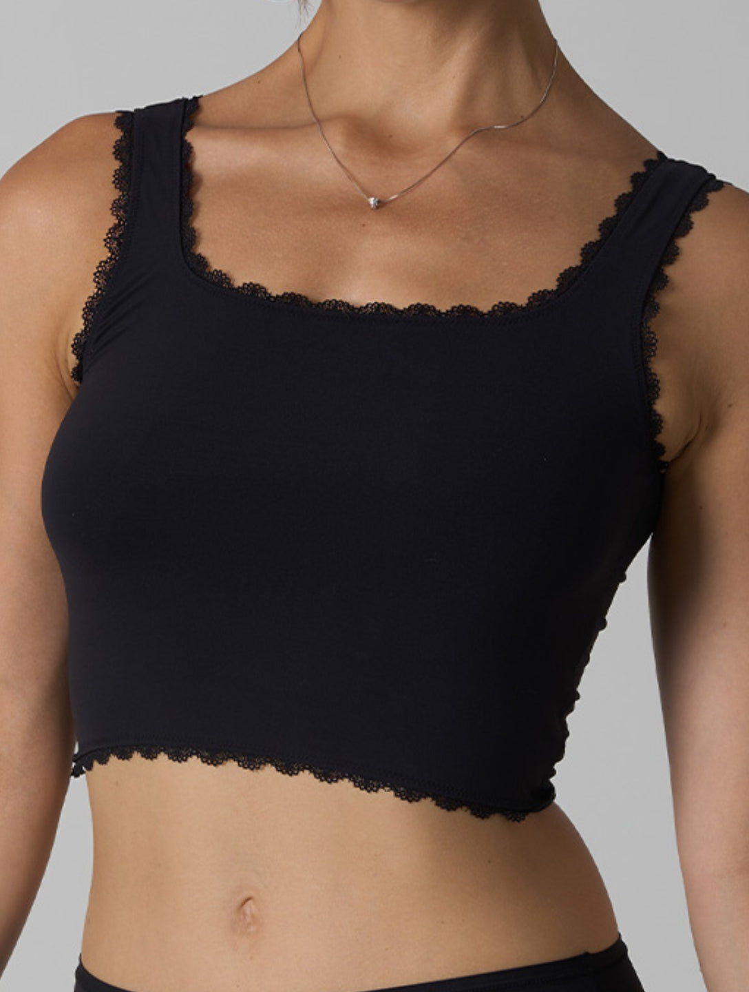 La camiseta sin mangas lisa de encaje